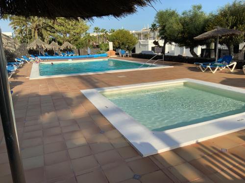 uma piscina num resort com piscina em Villa Oasis em Puerto del Carmen
