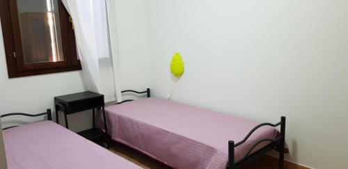 2 posti letto in una piccola camera con lenzuola viola di CASA VACANZE METAPONTO a Metaponto
