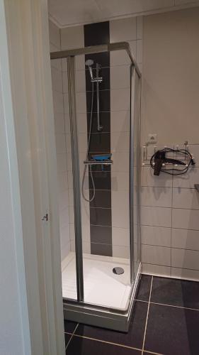 a shower with a glass door in a bathroom at Bed in de binnenstad ♡ bed downtown in Leeuwarden