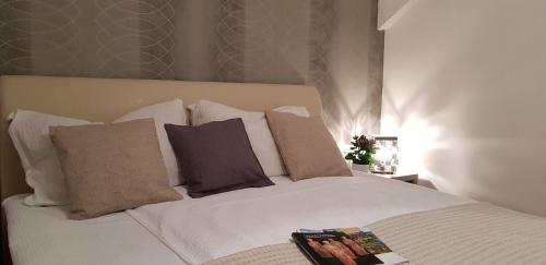 a bedroom with a white bed with pillows at Rooms Velo in Korenica