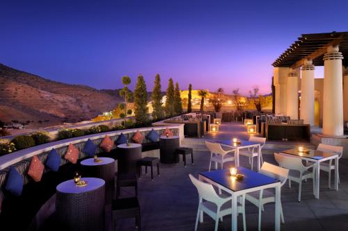 a dining room with tables and chairs and umbrellas at Mövenpick Resort Petra in Wadi Musa