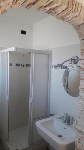 a white bathroom with a shower and a sink at VillAlbero B&B in Inveruno