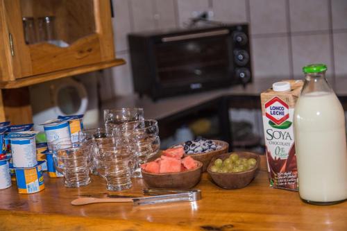 a counter with glasses and a bottle of milk at Apart hotel Puchaley Lafquen in Panguipulli