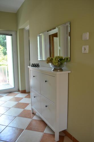a white dresser with a mirror on top of it at Magdaléna Holiday Home in Zalakaros