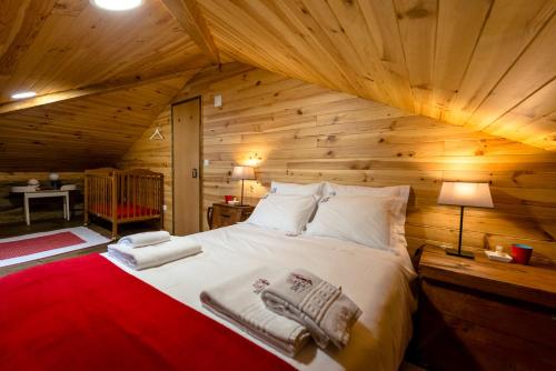 um quarto com uma cama num chalé de madeira em Casa do Silverio - Barroca em Barroca