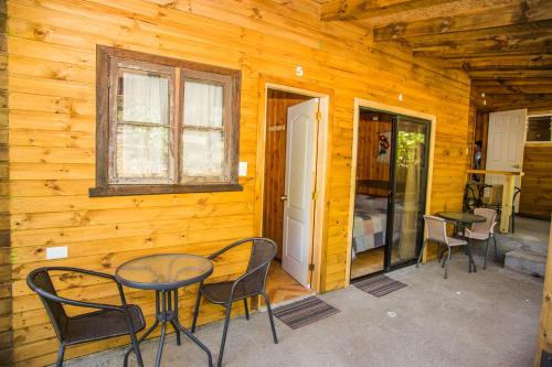 un patio con mesa y sillas en una cabaña en Refugio Ruka Cümelen en Panguipulli