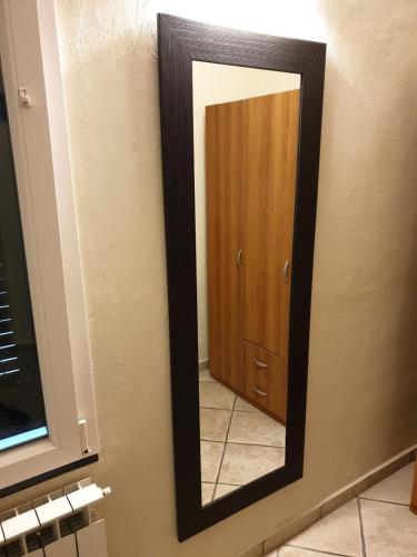 a mirror on a bathroom wall with a wooden door at B&B ALDA in Levanto