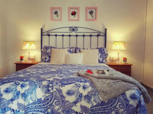 a bedroom with a blue and white bed with two lamps at Cortijo Buenavista in Málaga