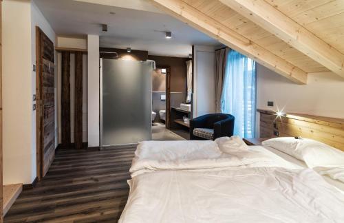 a bedroom with a large white bed and a desk at Chalet Vites Mountain Hotel in Canazei