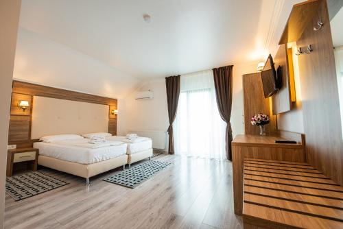 a hotel room with a bed and a window at Pensiunea Carul cu flori in Oraviţa