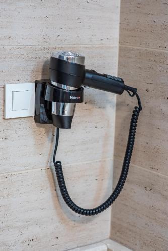 a camera attached to a wall with a cord at Pensiunea Carul cu flori in Oraviţa