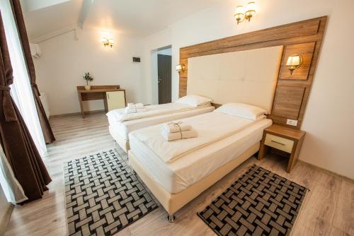 two beds in a room with two tables and a bed sidx sidx sidx at Pensiunea Carul cu flori in Oraviţa