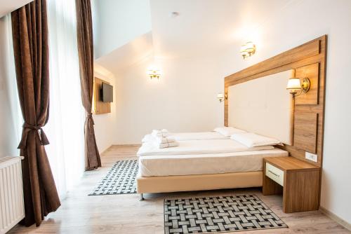 a bedroom with a bed with a wooden headboard at Pensiunea Carul cu flori in Oraviţa