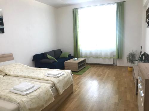 Un dormitorio con dos camas y un sofá azul. en Pasettistraße 31, en Viena