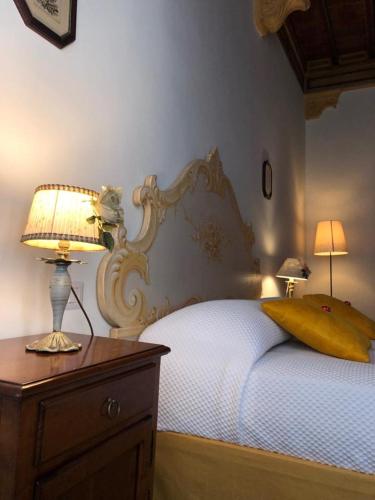a bedroom with a bed with a lamp on a dresser at BnB Paolina in Siena