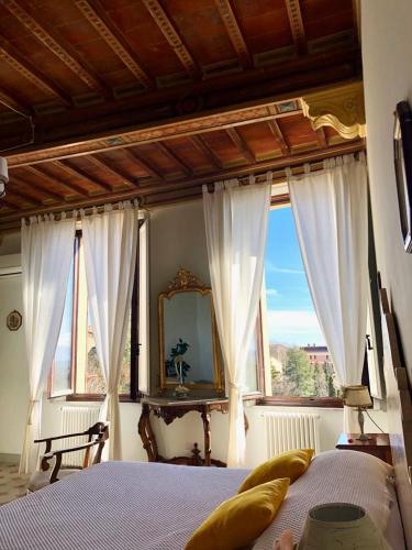 a bedroom with a bed with white curtains and a mirror at BnB Paolina in Siena
