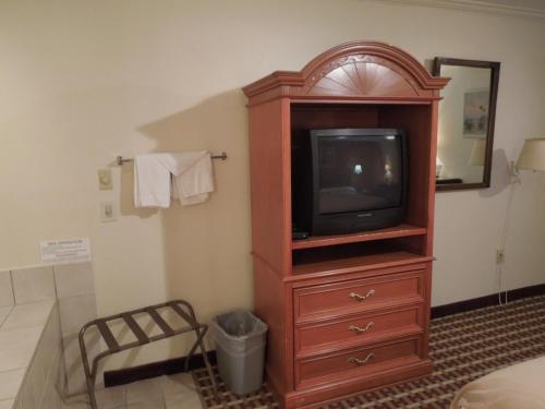 a tv in a wooden entertainment center in a hotel room at Wildwood Inn in Florence