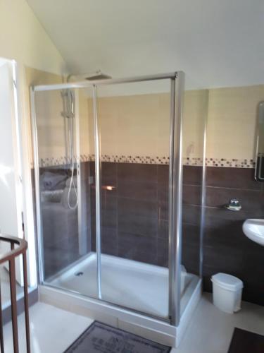 a glass shower in a bathroom with a sink at la ville à la campagne in Lisieux