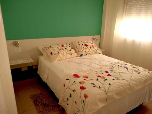 Un dormitorio con una cama con flores. en Estudio centrico en Resistencia en Resistencia