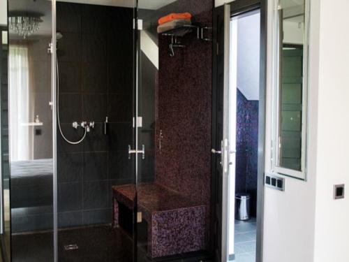 a bathroom with a shower with a bench in it at Boutique Hotel Bersas in Turaida