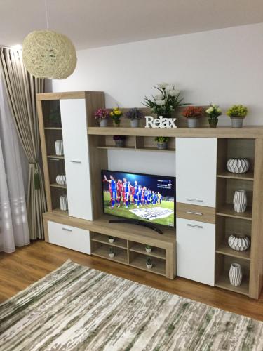 a living room with a television in a entertainment center at Roby apartament in Bucharest
