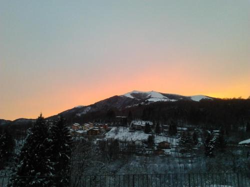 a mountain in the distance with the sun setting behind it at Hotel La Torre in Castiglione dʼIntelvi