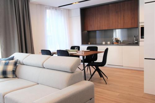 a living room with a white couch and a table at Lubicz Luxury Apartment in Kraków