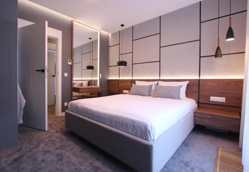 a bedroom with a large white bed and a desk at Lubicz Luxury Apartment in Kraków