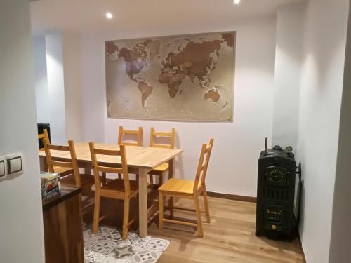 a dining room with a table and chairs and a map on the wall at Tirwal Suite in Teruel