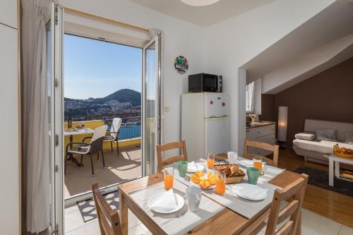 una cocina y una sala de estar con una mesa con comida. en Apartment NikoL, en Dubrovnik