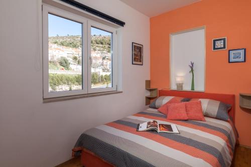 Un dormitorio con una cama con un libro. en Apartment NikoL, en Dubrovnik