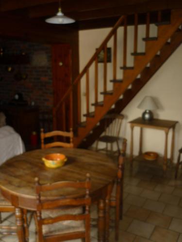 Diane Chasseresse في Soignies: غرفة طعام مع طاولة خشبية والدرج