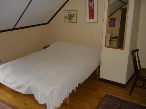 - une petite chambre avec un lit blanc et une chaise dans l'établissement Diane Chasseresse, à Soignies