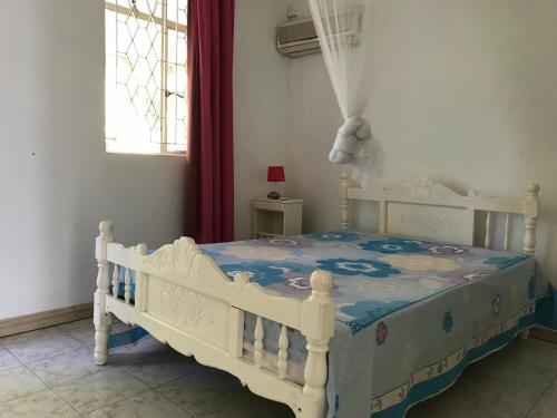 a bedroom with a white crib with a blue blanket at La Ballade in Trou aux Biches