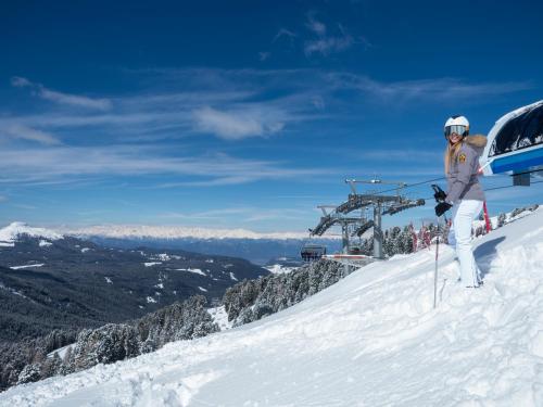 a person standing on top of a snow covered ski slope at Hotel Regglbergerhof in Nova Ponente