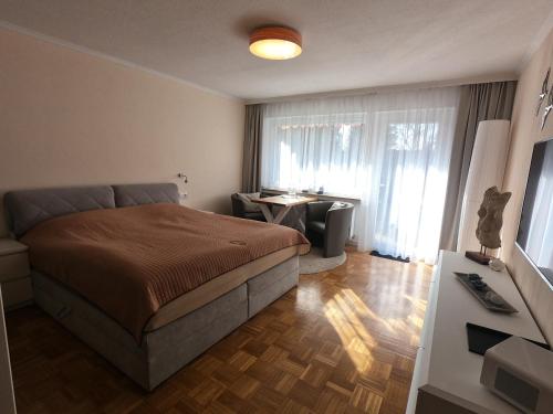 1 dormitorio con cama, escritorio y ventana en Bonsai-Apartment III An der Hufeland Therme en Bad Pyrmont