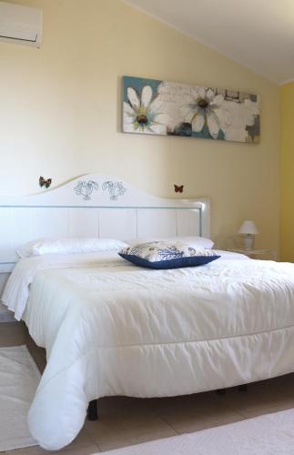 a bedroom with a white bed with a white headboard at La Rosa dei Venti in Sennariolo