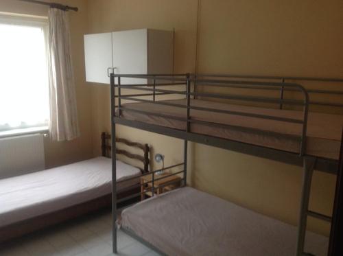 two bunk beds in a room with a window at Le Neptune in Koksijde