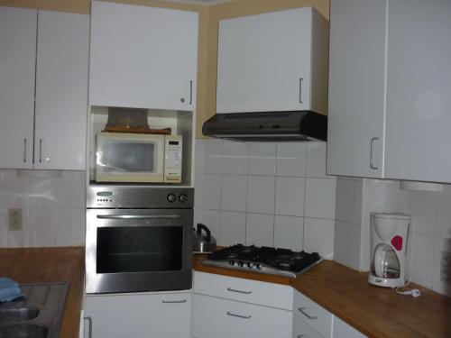 a kitchen with a microwave and a stove top oven at Le Neptune in Koksijde