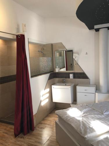 a bathroom with a bed and a sink and mirror at Center Rooms Villach in Villach