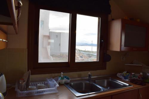 Agios OnoufriosにあるMichalis Apartmentのキッチンカウンター(シンク付)、窓