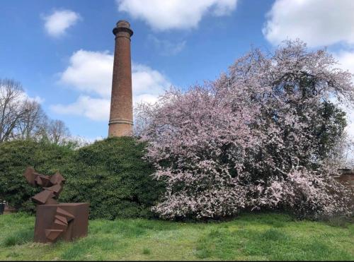 a flowering tree with a tower in the background at La Fornace in Alessandria