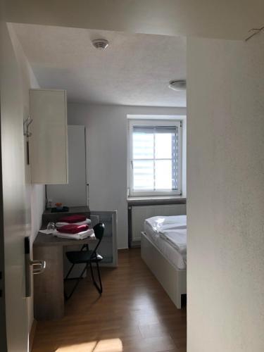 a bedroom with a bed and a desk and a window at Center Rooms Villach in Villach