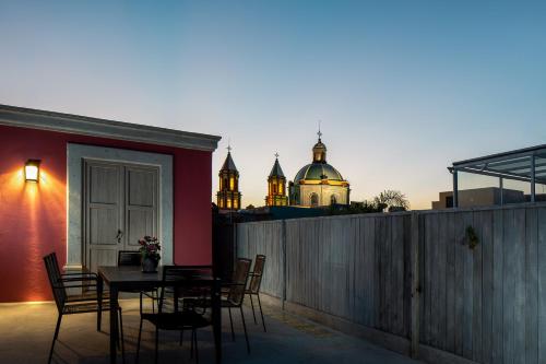 a patio with a table and chairs and a building at Hotel Casa Once in Querétaro
