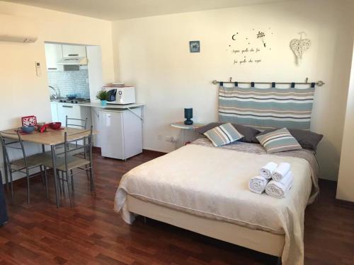 a bedroom with a bed and a table and a kitchen at Blue Apartment in Pescara