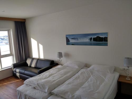 a bedroom with a couch and a window at Hafdals Hotel in Akureyri