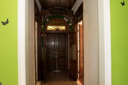 a hallway with a wooden door and green walls at Casa Mayela Guest House in San José