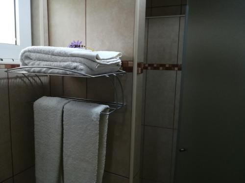 a pile of towels on a towel rack in a bathroom at A Casa da avó Custodinha in Bias do Norte