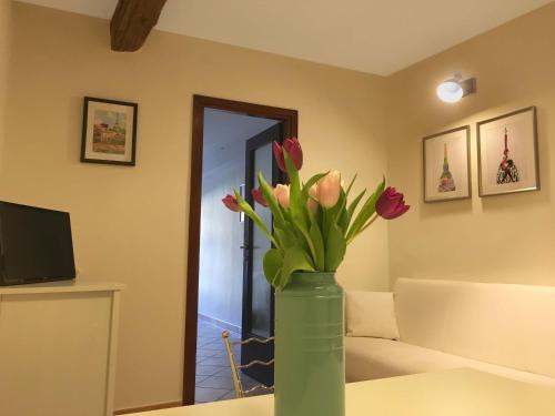 een groene vaas met bloemen op een tafel in een kamer bij Nido del Cuore in Turijn