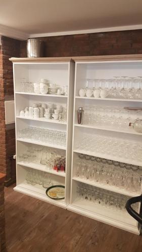 a white refrigerator filled with lots of glasses and dishes at Feierabend Elsdorf in Elsdorf